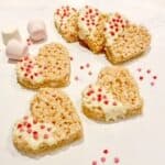 Six heart shaped rice krispy treats on a white background.