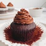 gluten free chocolate cupcakes with chocolate frosting with a pot of chocolate in the background
