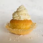 gluten free vanilla cupcake with buttercream frosting on a marble backdrop