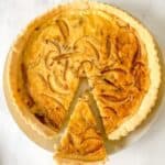 gluten free cheese and onion quiche with a slice cut into it