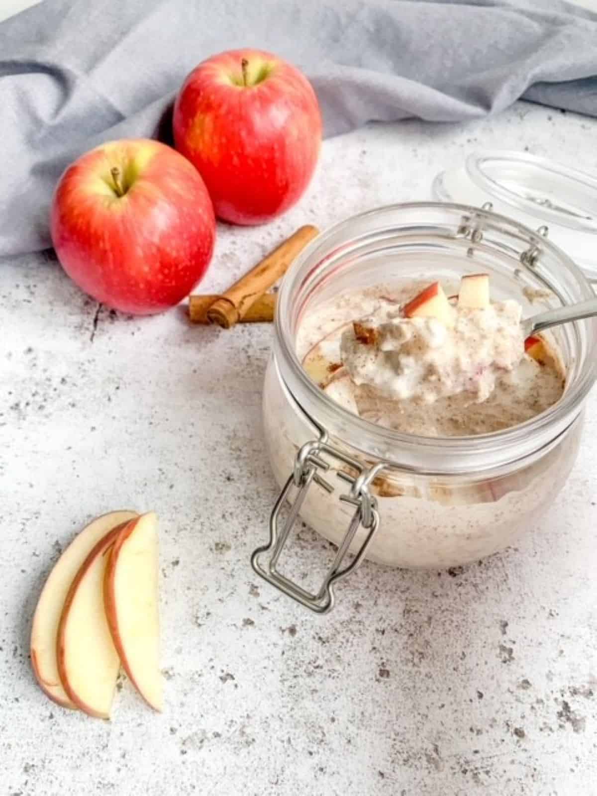 apple cinnamon overnight oats in a mason jar with a small spoon.