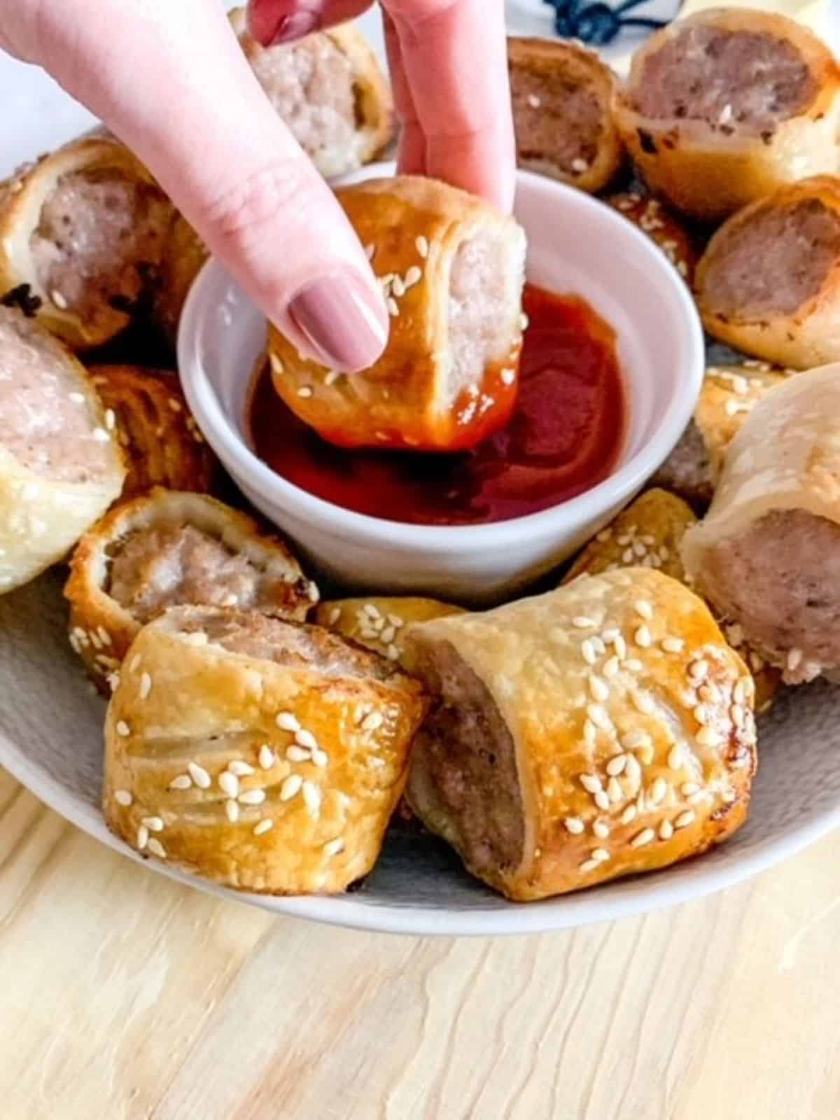 mini sausage roll being dipped in tomato ketchup
