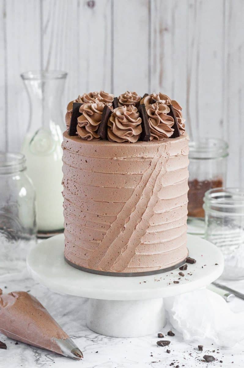 gluten free chocolate cake on a white cake stand 