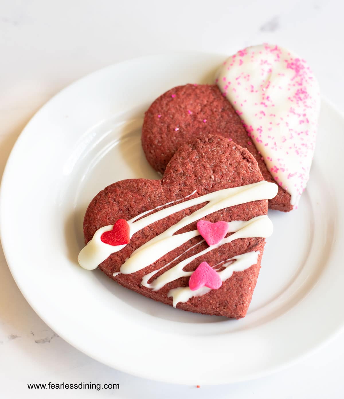 red velvet heart cookies on a white plate