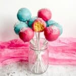 pink and blue gluten free cake pops in a clear jar.