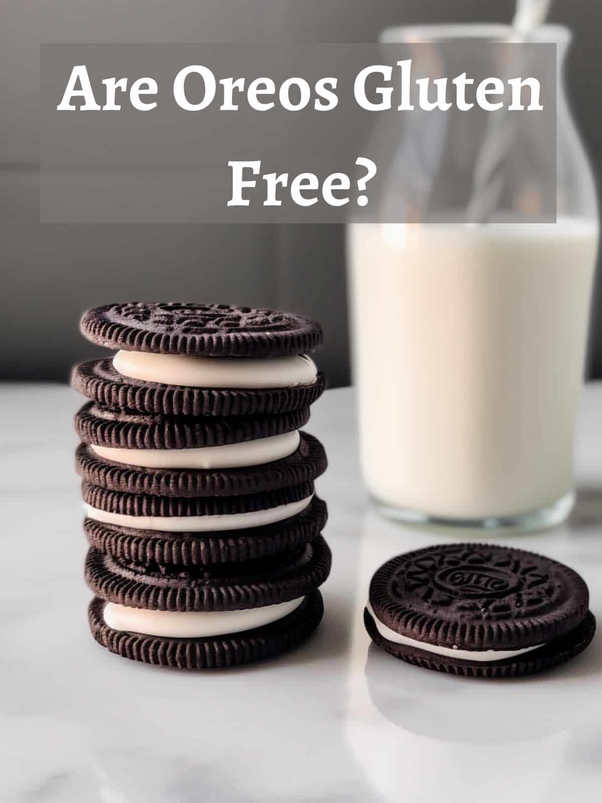 Oreos are stacked together on a marble surface with a glass of milk in the background.