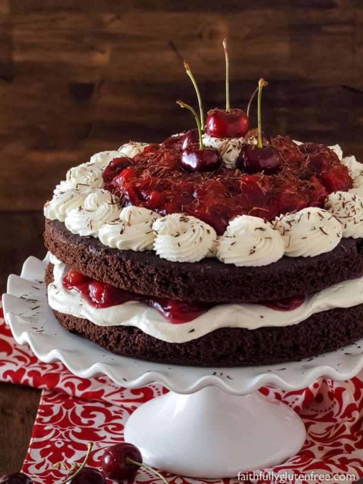 Black forest cake on a white cake stand.