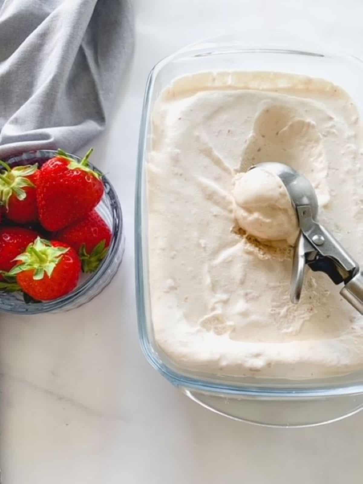 strawberry ice cream being scooped with an ice cream scoop.