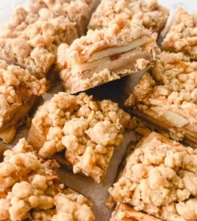 Sliced apple pie bars on a white surface.