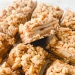 Sliced apple pie bars on a white surface.