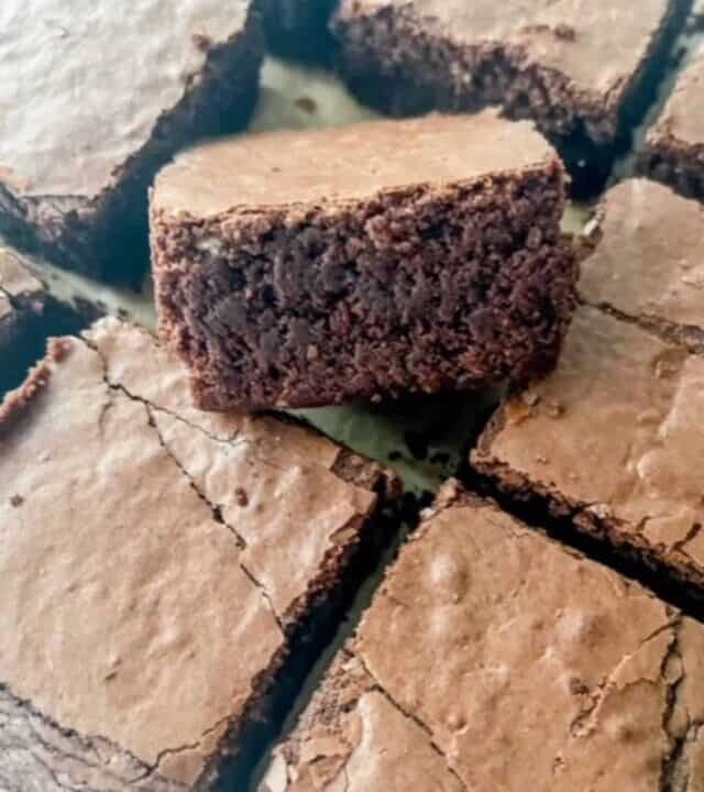 Close up of gluten free chocolate brownies sliced into squares on a white background.