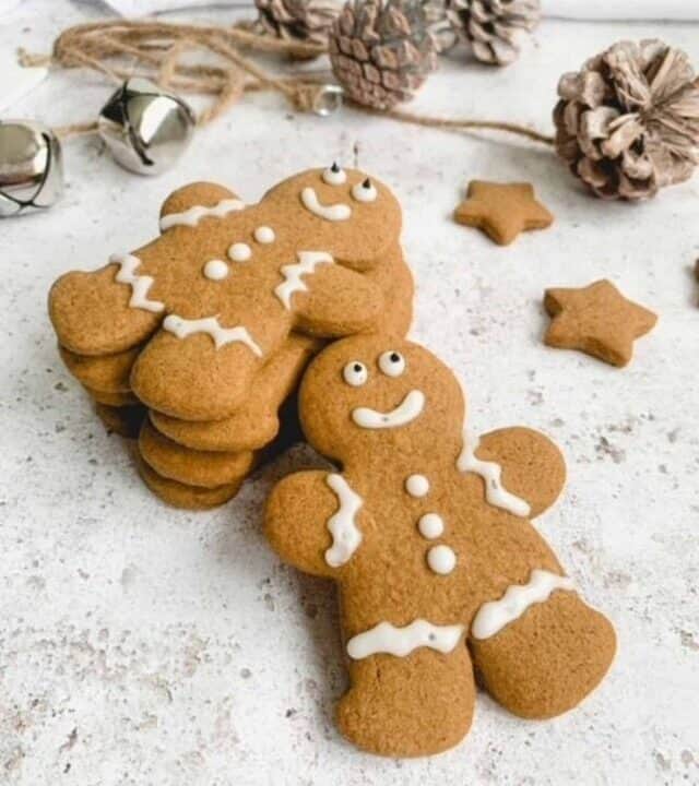 Gluten free gingerbread men stacked together with acorns in the background.