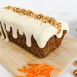 Gluten free carrot loaf cake on a wooden chopping board.