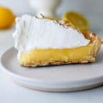 A slice of gluten free lemon meringue pie on white plate.