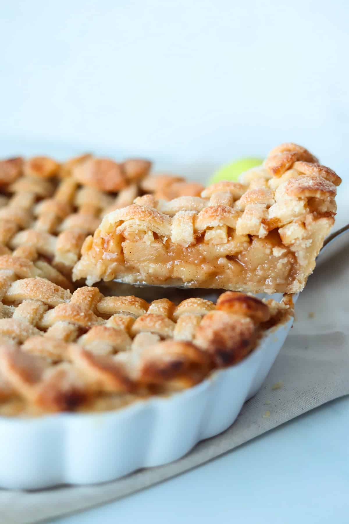 A slice of gluten free apple pie is being removed from the pie dish.
