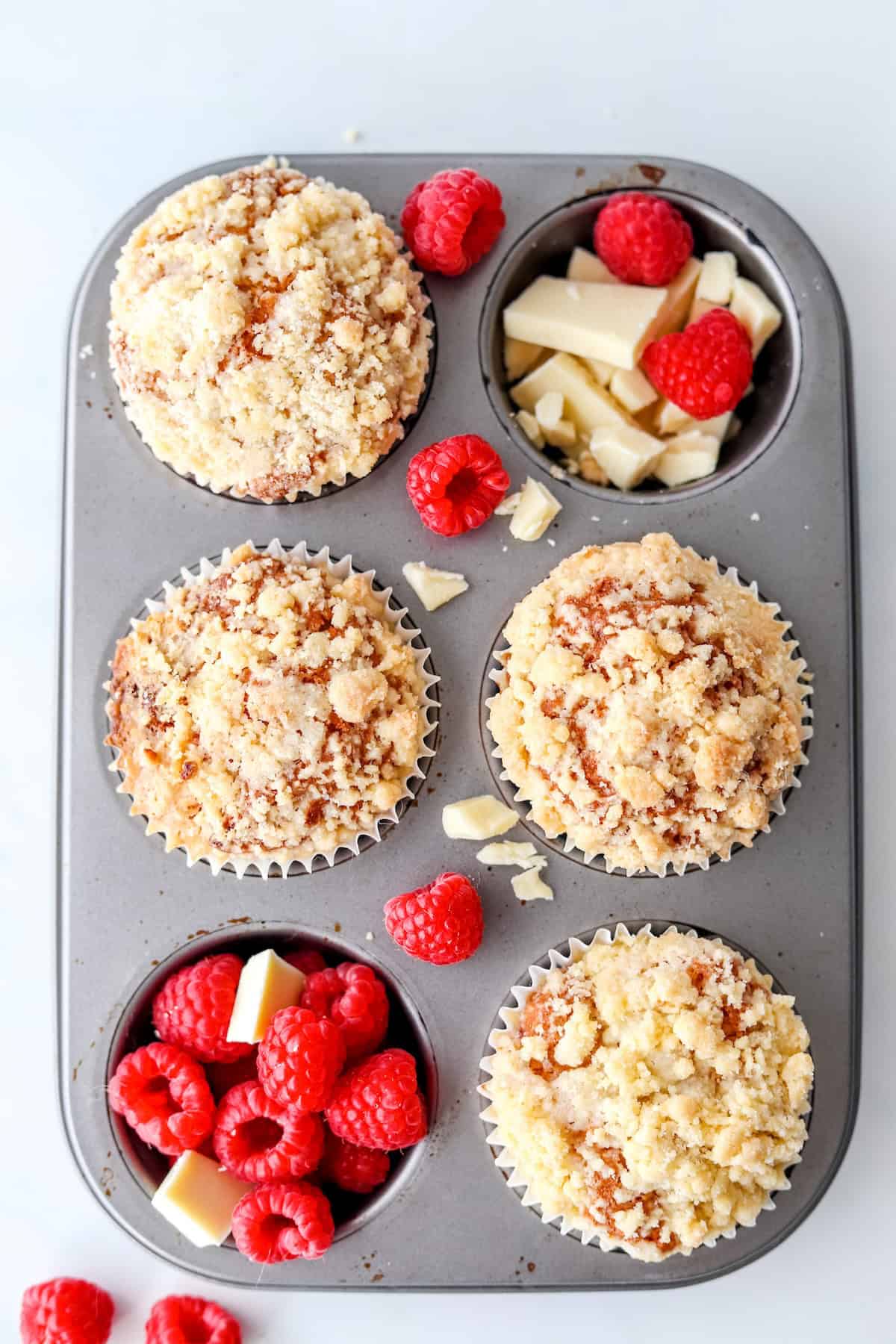 Fully baked gluten free raspberry muffins in a muffin pan.