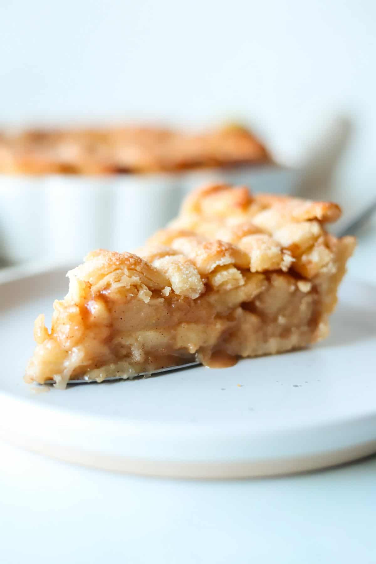 A slice of gluten free apple pie on a white plate.