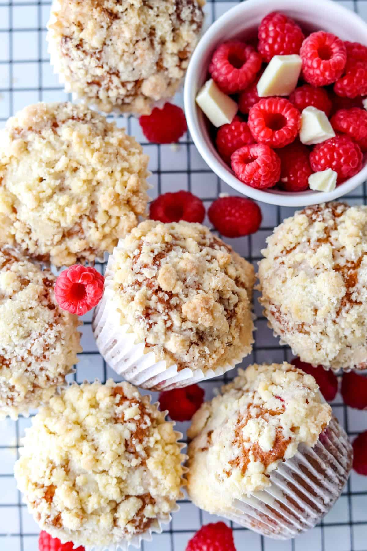 Close up shot of gluten free raspberry muffins surrounded by fresh raspberries.