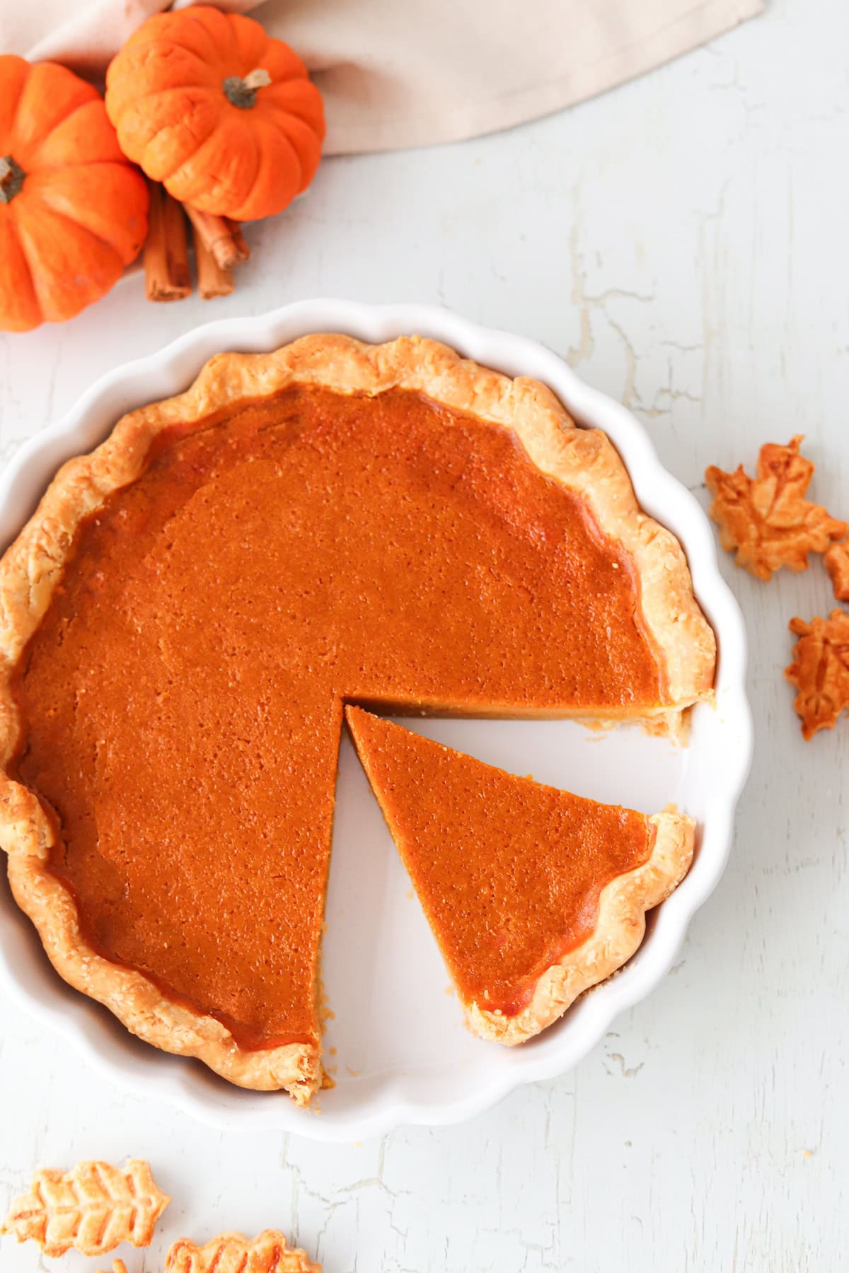 Overhead shot of gluten free pumpkin pie with a slice removed in a white pie dish.
