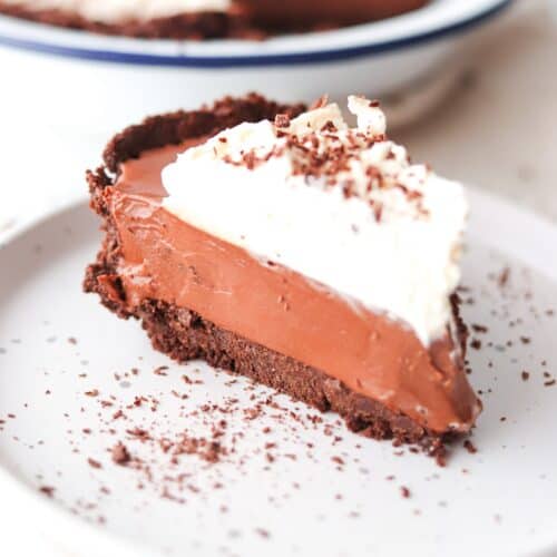 A slice of chocolate French silk pie with Oreo crust on a white plate.