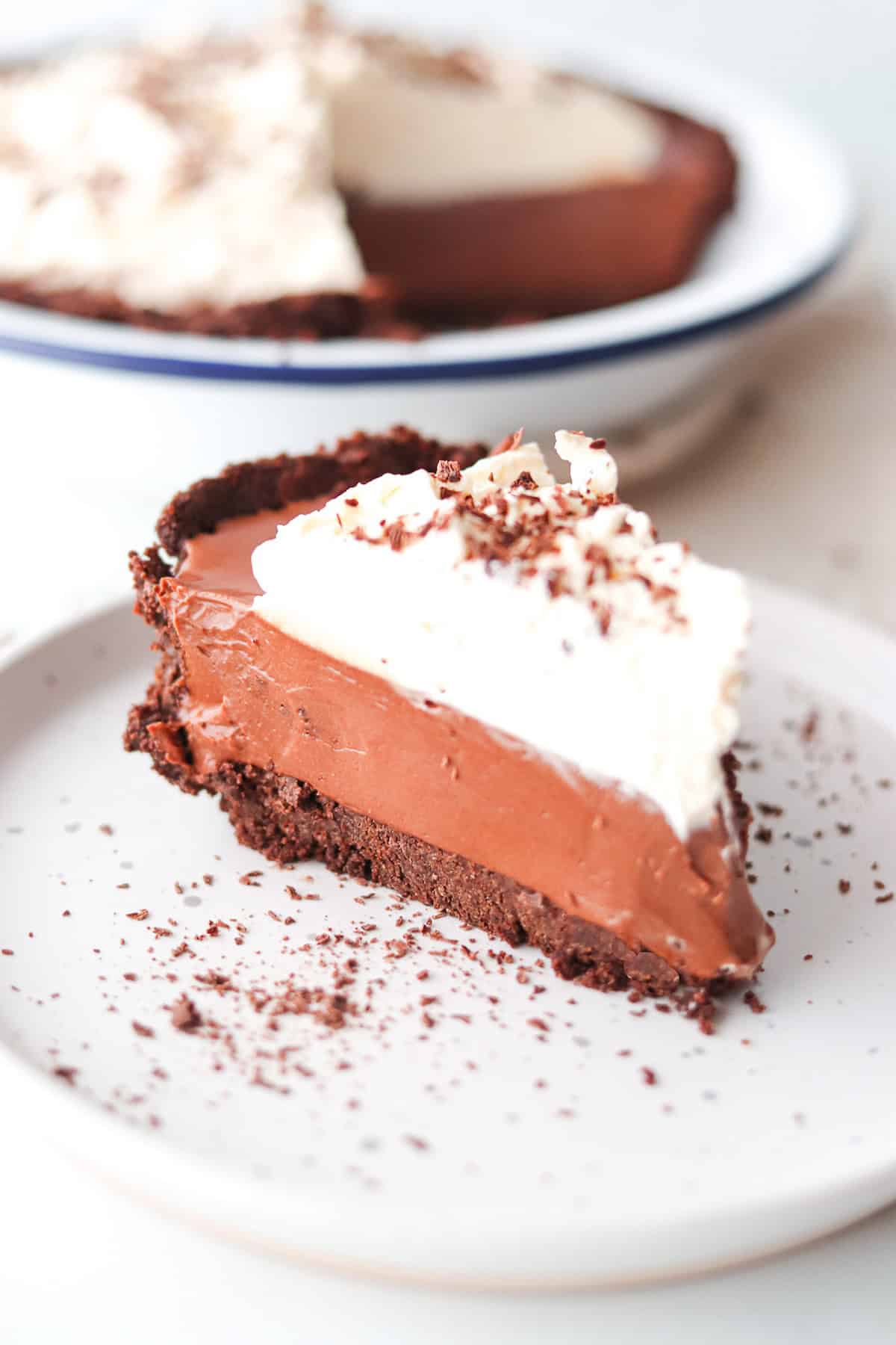 A slice of chocolate French silk pie with Oreo crust on a white plate.