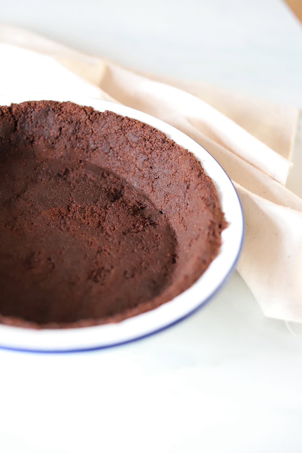 Close-up image of Oreo pie crust in a white pie dish.