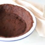Close-up image of Oreo pie crust in a white pie dish.
