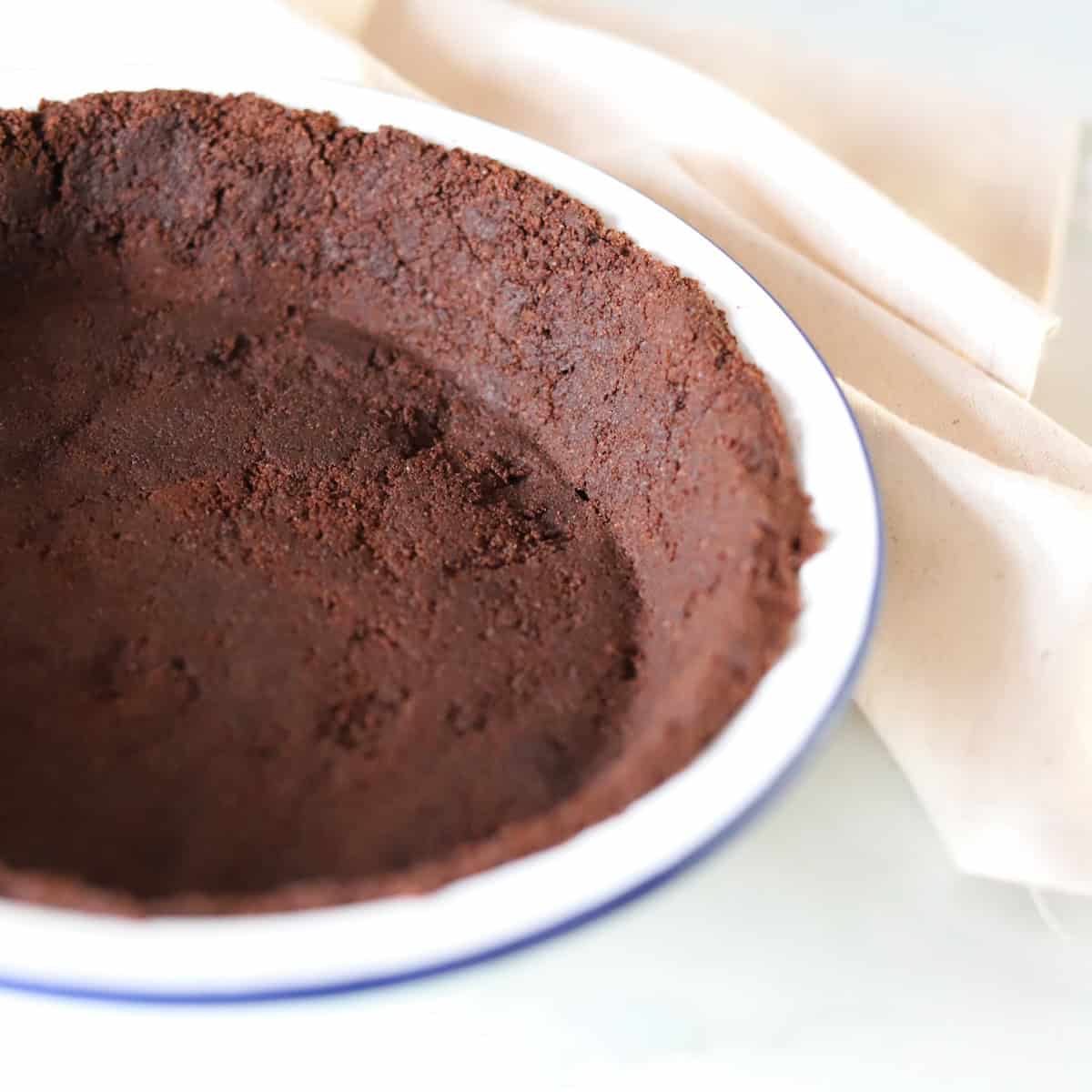 Close-up image of Oreo pie crust in a white pie dish.