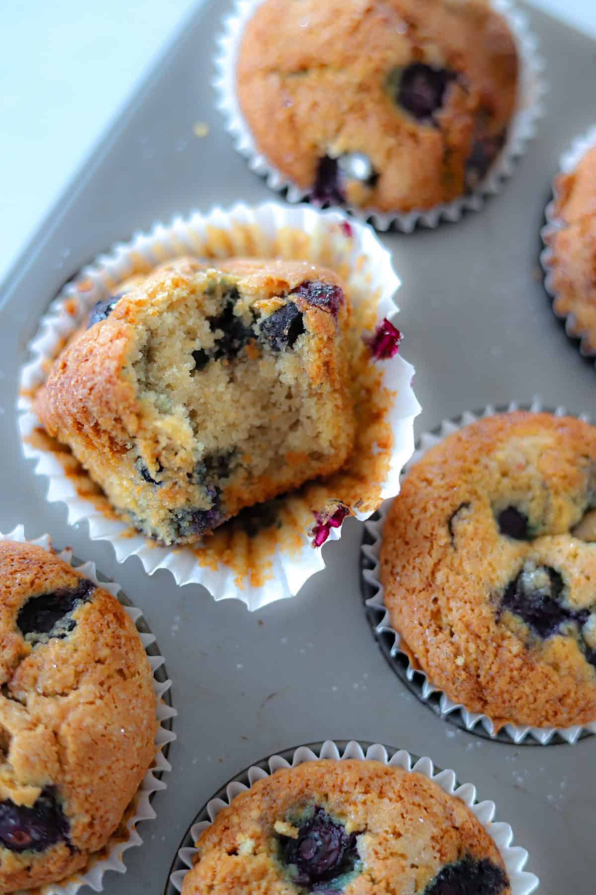 Close-up of a blueberry muffin with a bite taken out.