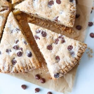 Close up of sliced gluten free chocolate chip shortbread on a white background.