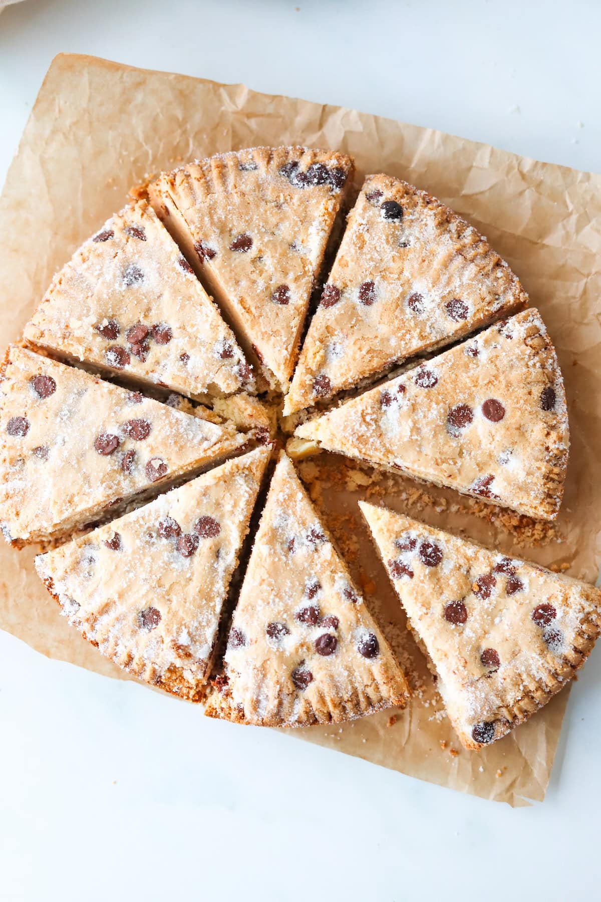 Close up of sliced gluten free chocolate chip shortbread on a white background.
