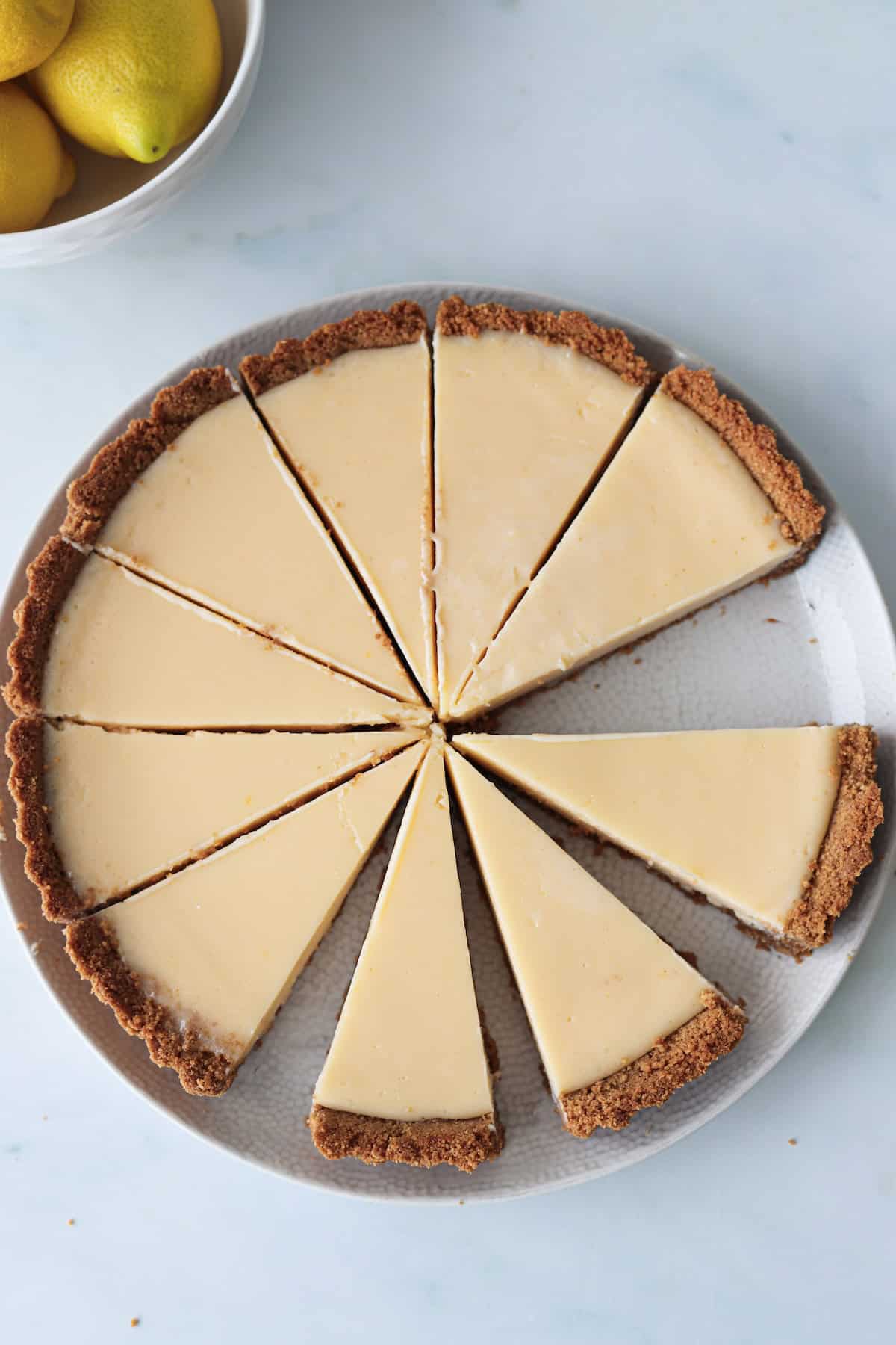 Overhead shot of a sliced gluten free lemon pie on a white background.