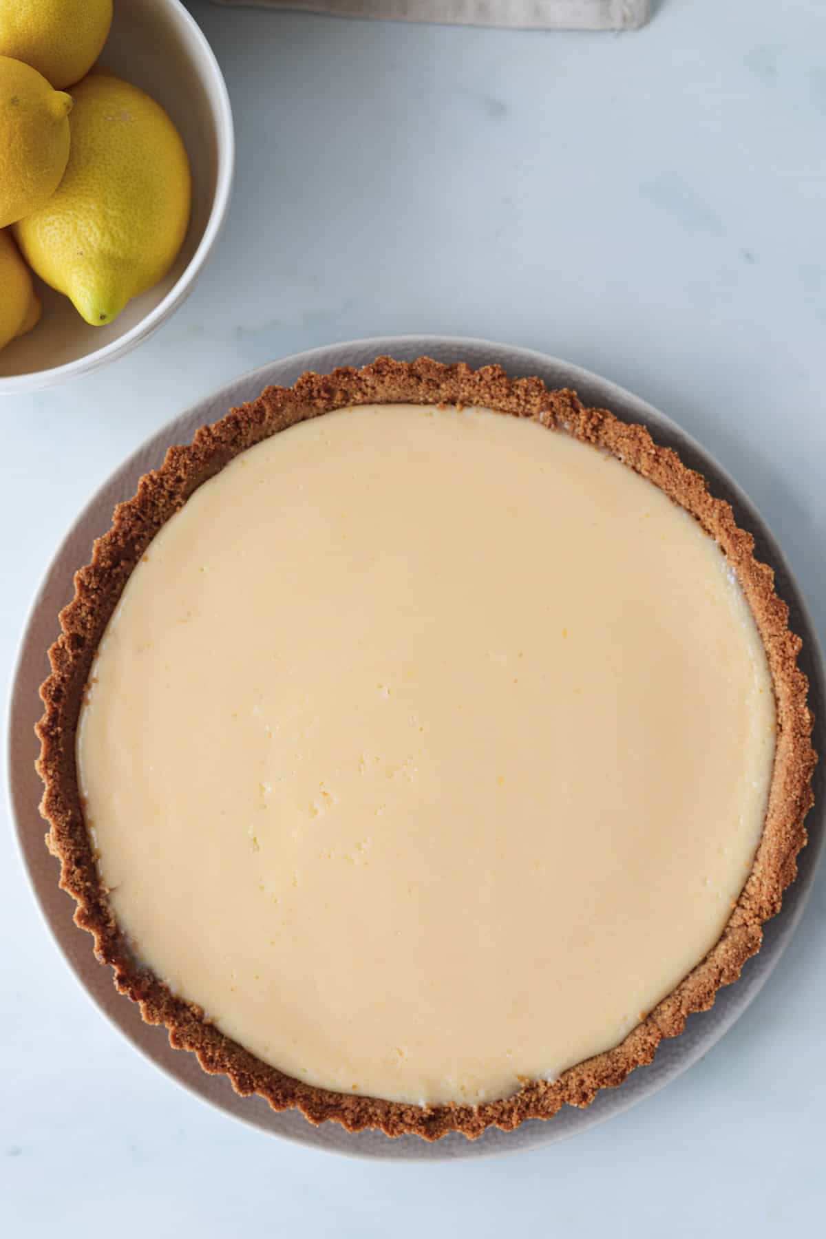 Overhead shot of a gluten free lemon pie on a white background.
